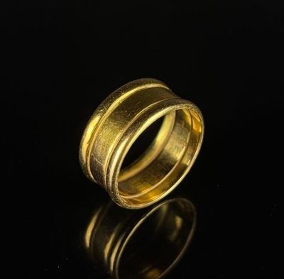 a close up of a gold ring on a black surface
