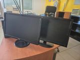 deux écrans d'ordinateur posés sur un bureau en bois