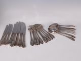 a lot of silverware on a white table