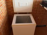 a small white chest freezer in the corner of a room