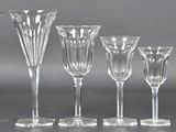 quatre verres à vin et un vase posés sur une table