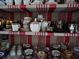 de nombreuses tasses et soucoupes sur les étagères de la pièce