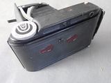 a black camera with a white button and a black case