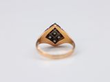 a close up of a gold ring with a black diamond