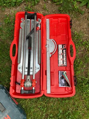 une boîte à outils rouge contenant des outils, posée sur l'herbe