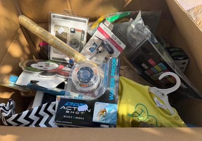 a cardboard box filled with assorted items and a camera