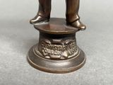 a bronze statue of a man standing on top of a pedestal