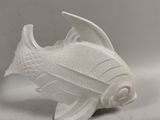 a white ceramic fish that is sitting on a table