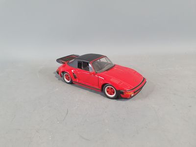 a red toy car that is on a white surface