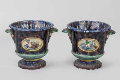 une paire de vases bleus et verts sur lesquels est représenté un homme et une femme