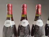 three bottles of red wine are lined up on a table