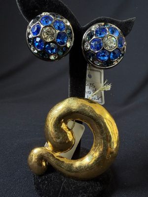 a black cat with blue eyes sitting on top of a gold object