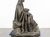 sculpture of a woman sitting on a platform with a baby