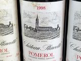 three bottles of red wine are lined up on a shelf