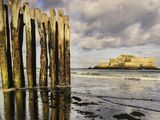 a wooden structure on the beach next to the water