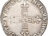a close up of a silver coin with a cross on it