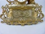 a gold clock sitting on top of a white table