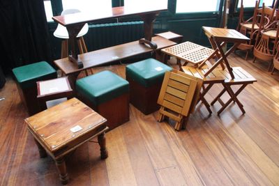 de nombreuses tables et tabourets en bois dans une pièce
