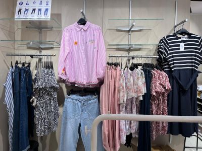 a lot of clothes hanging on a rack in a store