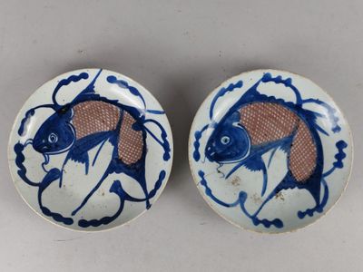 deux assiettes bleues et blanches ornées de motifs de poissons, posées sur une table