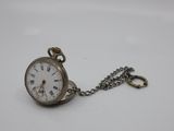 an old pocket watch with a chain hanging from it ' s side