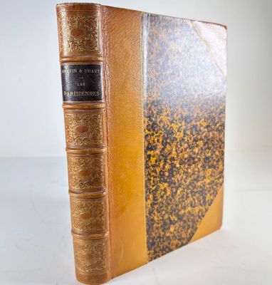 an old book with a gold cover and a black binding