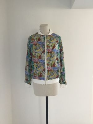 an image of a jacket on a mannequin stand in front of a window