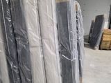 de nombreux matelas emballés dans du plastique dans un entrepôt
