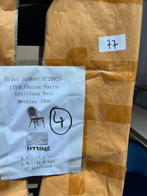 a sign on the back of a chair that is wrapped in brown paper