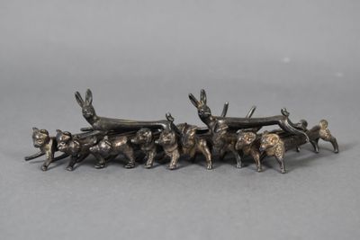 a silver figurine of a group of animals pulling a wagon