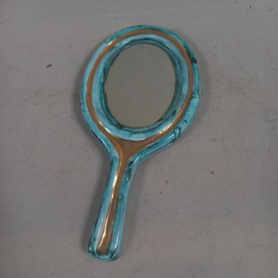 Petit MIROIR en faïence émaillée et doré à décor floral.