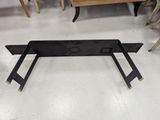 a black metal bench in a room with many chairs in the background
