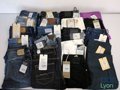 beaucoup de jeans empilés les uns sur les autres sur une table