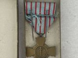 a small box with a medal in it on a white surface
