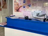 un comptoir bleu et blanc dans un magasin, avec des affiches accrochées au mur
