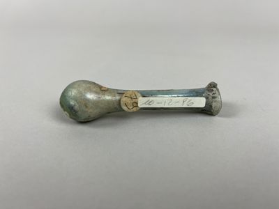 gros plan d'un petit objet métallique sur une surface blanche