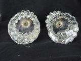 pair of clear glass candlesticks on a black background