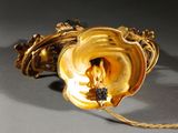 a gold vase with a flower on it sitting on a table
