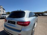 a silver mercedes suv parked in a parking lot next to a building