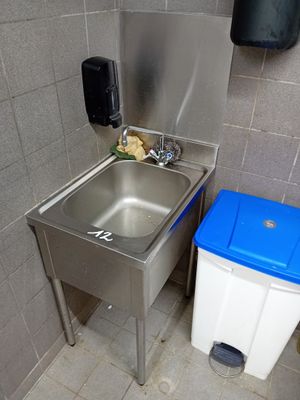 un lavabo et une poubelle dans des toilettes publiques