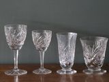sept verres à vin alignés sur une table en bois