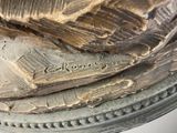 a close up of a sculpture of a bird on a pedestal