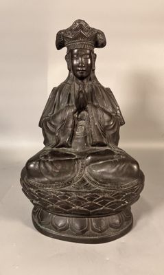 an old statue of a woman sitting on top of a bowl
