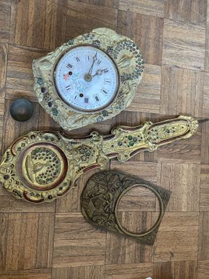 une horloge posée par terre à côté d'autres objets