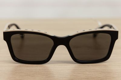 black and white sunglasses on a wooden table with a white background