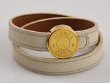 leather bracelet with a gold button on a white background