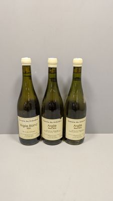 trois bouteilles de vin posées sur une table, l'une à côté de l'autre