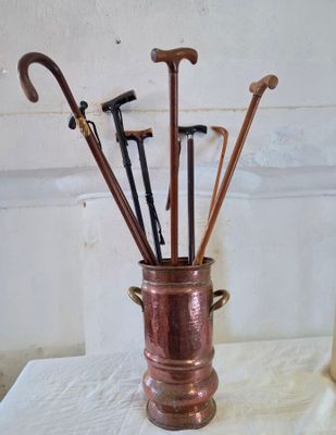 un bouquet de parapluies disposés dans un vase posé sur une table