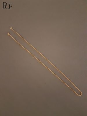 une paire d'aiguilles à tricoter plaquées or posées sur une table