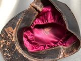 a brown hat with a pink satin inside of it